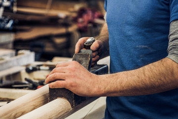 Poster - Man smoothing a piece of wood using a traditional plane