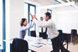 © BullRun - Happy businesspeople giving high five in office