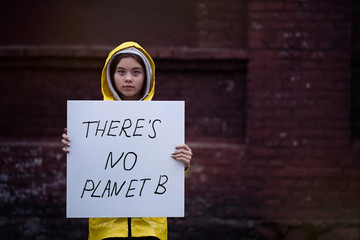 teenager girl holding placard during global strike for climate change