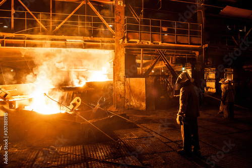 Fotografía Steelworkers when pouring liquid titanium slag from arc furnace