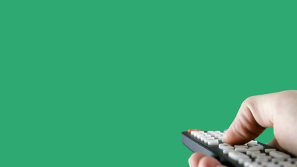 Hand using a remote control over a green screen background