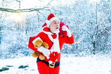 Real Santa Claus In Red Cap Pulling Large Red Gift Sack. Christmas Celebration Holiday. Merry Christmas And Happy New Year Concept.