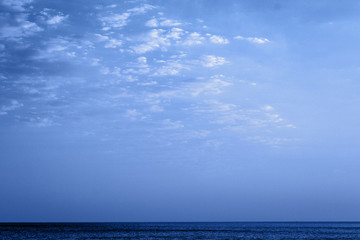 Dark blue night at seaside, dramatic clouds, space for text