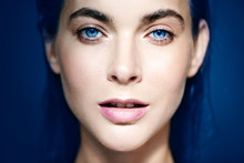Portrait Of Beautiful Blue-eyed Woman On Blue Background.