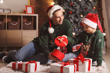 Poster - Little boy and his father opening Christmas gifts at home