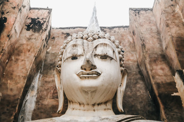 Wall Mural - Ruins temple Sukothai historical park, Unesco world heritage, Thailand, the body to head part of the big buddha image at Wat Sri Chum in Sukhothai.