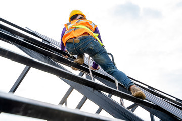 Wall Mural - Construction worker wearing safety harness and safety line working on high roofing work instal new roof.