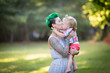 © IrinaN - A portrait of Caucasian young woman with green hair and tattoo holding a blond toddler boy in her hands. Hugging, Mother's day concept