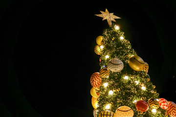 Wall Mural - Look up view of Christmas tree and decorate with led lighting isolate on black background.