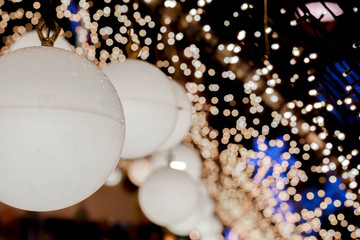 Wall Mural - Closeup decorate Christmas lamps hang interior tunnel lights on blurred and bokeh of led reflection lightning in night time background.