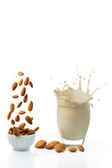 Sticker - glass with almond milk and sketch. separate bowl with shelled almonds. White background