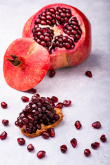 Wall Mural - Juicy and fresh pomegranate, whole and cut, with seeds in the foreground