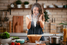 Young Woman In Kitchen. Beautiful Woman Playing With Flour.