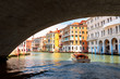 Grand Canal in summer, Venice, Italy. Motor boat sails under famous Rialto Bridge, landmark of Venice.