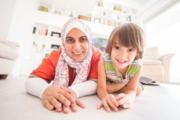 Wall Mural - Muslim traditional mother with little cute son at home in living room