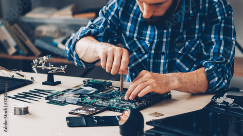 Fotografía Hardware diagnostics. Electronic parts. Engineer fixing laptop.