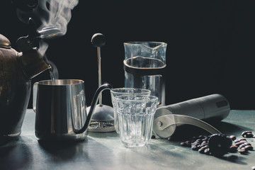 Wall Mural - Aromatic coffees in French press coffee maker with couple glass and Antique coffee bean grinder using hand crank,Hot drink is good for health,Wood table,Black background,Natural light,Healthy Eating.