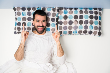 Man in bed in top view pointing up a great idea