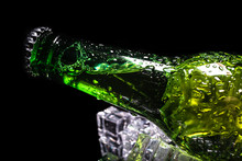 Cold Beer In A Green Bottle, With Water Drops And Ice Cubes, With Dark Background