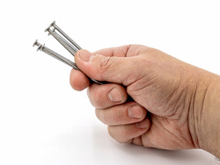 Wall Mural - Man holding construction nails in his hand on a white isolated background_