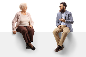 Sticker - Senior woman and a bearded man sitting on a panel and talking