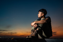 Black Asian Man And Bearded On Face With Cool Haircut Wear Tactical Suit And Hard Brown Boots Makes Depress Face Looking For Future And Redemption In Beautiful Evening Twilight Time Photo Stock