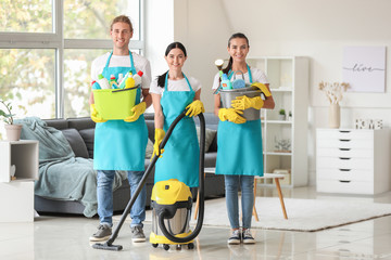 Wall Mural - Team of janitors with cleaning supplies in flat