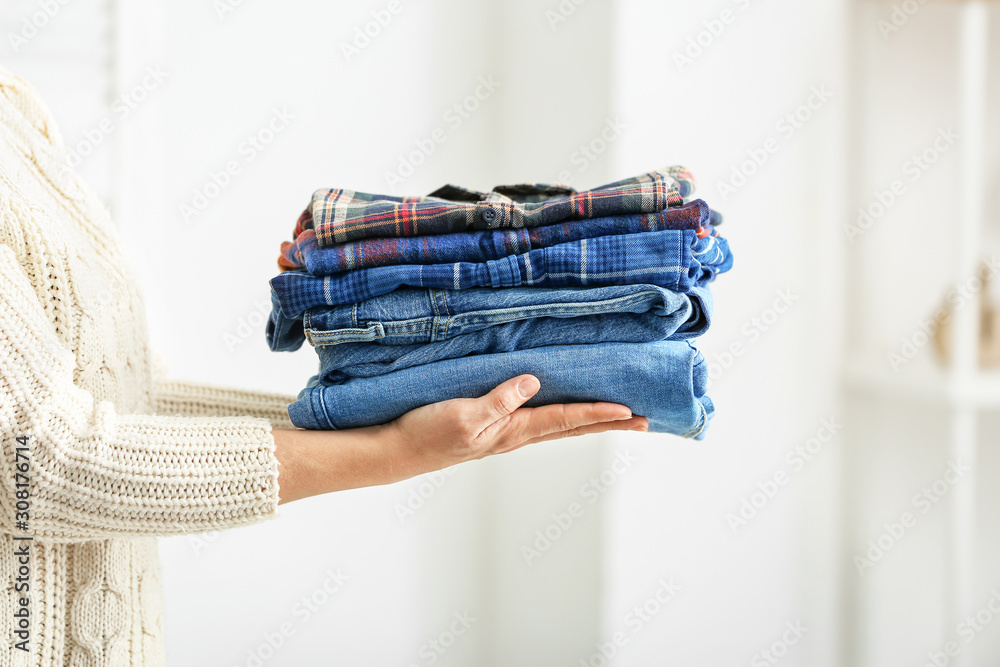 Woman with stack of clean clothes, closeup