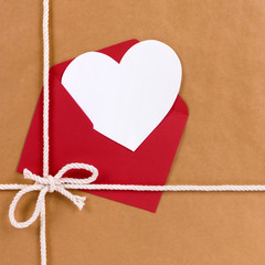 Wall Mural - Valentines day gift with white heart shape card, red envelope, brown paper package parcel background