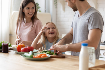 Wall Mural - Daughter spend time with parents while they preparing healthy dinner