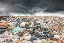 Garbage Dump Pile In Trash Dump Or Landfill,truck Is Dumping The Gabage From Municipal,garbage Dump Pile And Dark Clouds Or Rain Clouds Background ,pollution Concept.