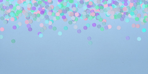 Pastel color confetti scattered on a blue background.