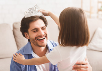 Wall Mural - little girl putting crown on her dad head