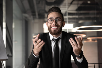 Smiling Arabian businessman having video call in office