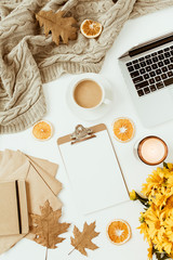 Wall Mural - Flat lay home office table desk workspace with blank copy space clipboard, flowers bouquet, coffee cup, blanket, envelopes, leaves on white background. Top view girl boss business, work concept.