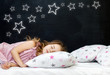 © photo_mts - Charming little girl of preschool age sleeps in bed on a pillow with stars. Time to sleep. Abstract background about space and the dreams of a child. A journey in a dream. Happy childhood