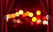 © adam121 - Bokeh lights behind drapery curtain and hand opening it