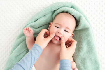 baby face massage background. mother gently stroking baby boy face with both hands. close up cropped