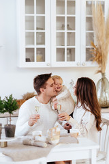 a young family, father, pregnant mother and their little daughter have a fun and playing in the kitchen