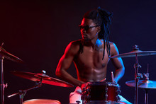 Good-looking Artistic African Black Male Drummer Enjoying Playing Drums Over Dark Background