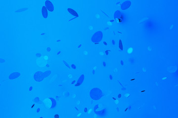 blue confetti on blue background. trendy classic blue tinting