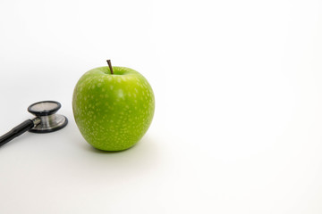  green apple with stethoscope in isolated white background. healthy diet concept