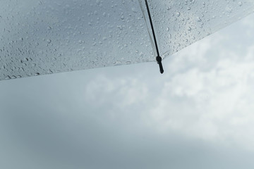 Rain drops on umbrella with rainy cloud sky, rain season concept