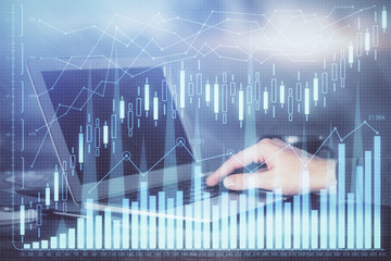 Double exposure of businessman with laptop and stock market forex chart.