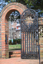 Brick Archway And Wall With Decorative Metal Door