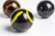 group of opaque glass marbles in black with yellow and orange