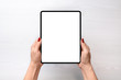 © Stanisic Vladimir - Tablet mockup. Girl holding tablet in vertical position abowe white desk. Flat lay, top view