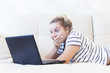 © Petr - blonde girl is sitting at home on the couch with a laptop and communicates on the Internet. social networks. dating.