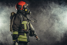 Strong Firefighter In Protective Suit And Helmet Use Special Equipment For Preventing Fire And Save People And Animals From Fire