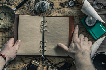 Aufkleber - Travel planning around the world trip. A finger roaming the map. An open notebook with space for text. Things useful in the expedition. Retro styl